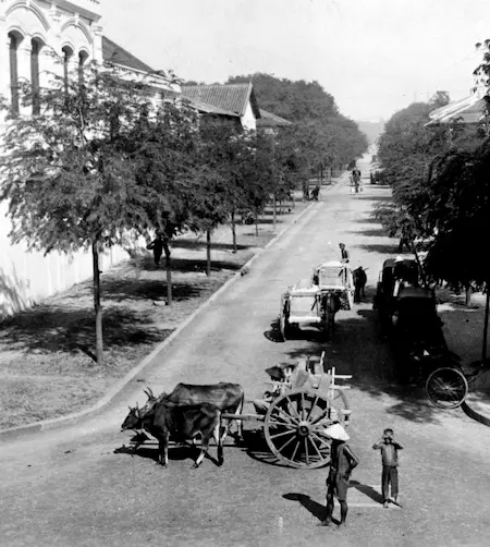 Historical photograph of a bustling street in Saigon during the 1910s, showcasing early 20th-century urban life